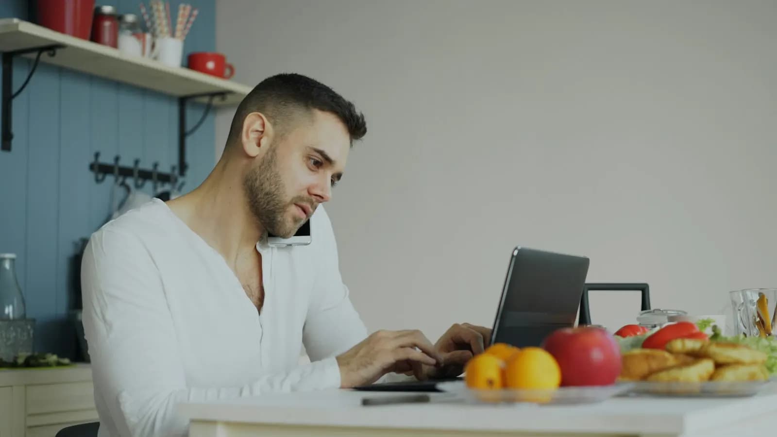 Landlord checking his properties on a laptop at the kitchen table