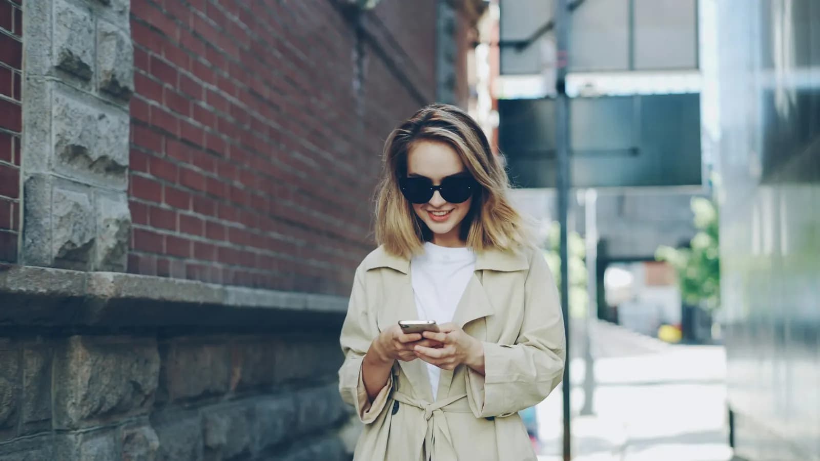 Letting agent checking her phone on a city street