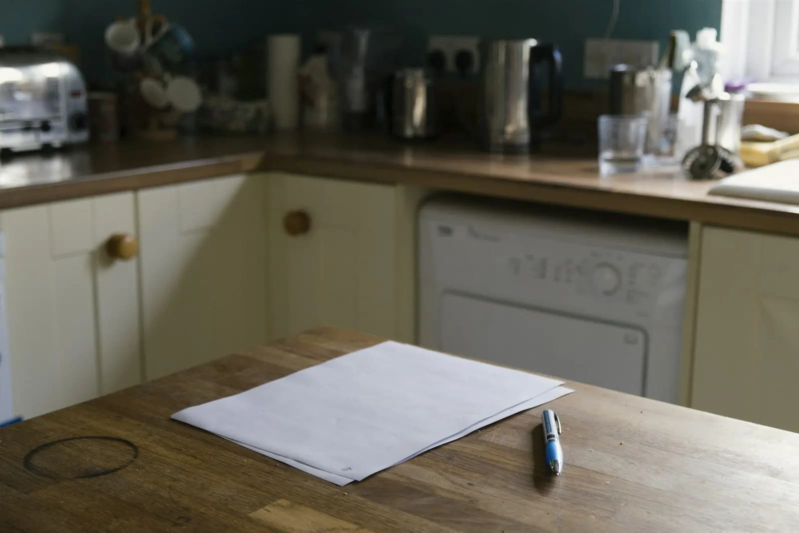 Paperwork and a pen on a kitchen worktop